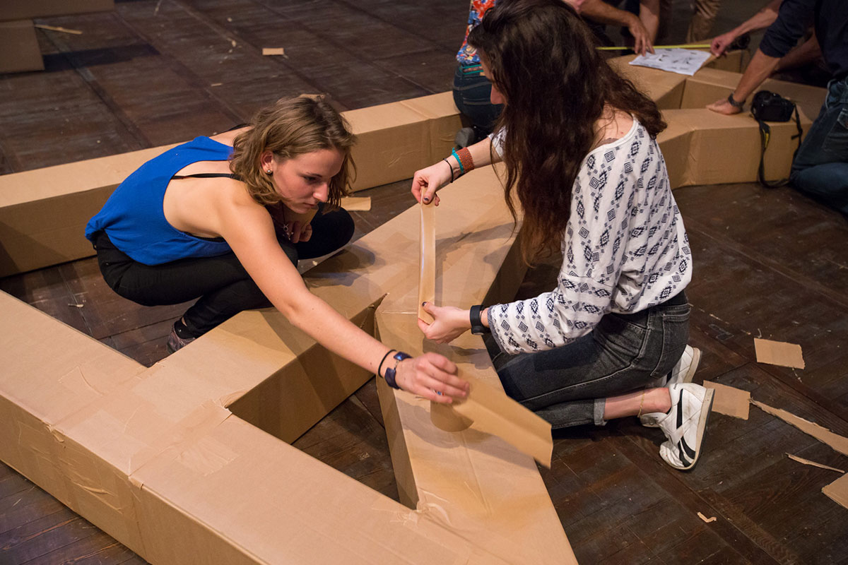 ダンボールをテープで繋いでいるワークショップの様子